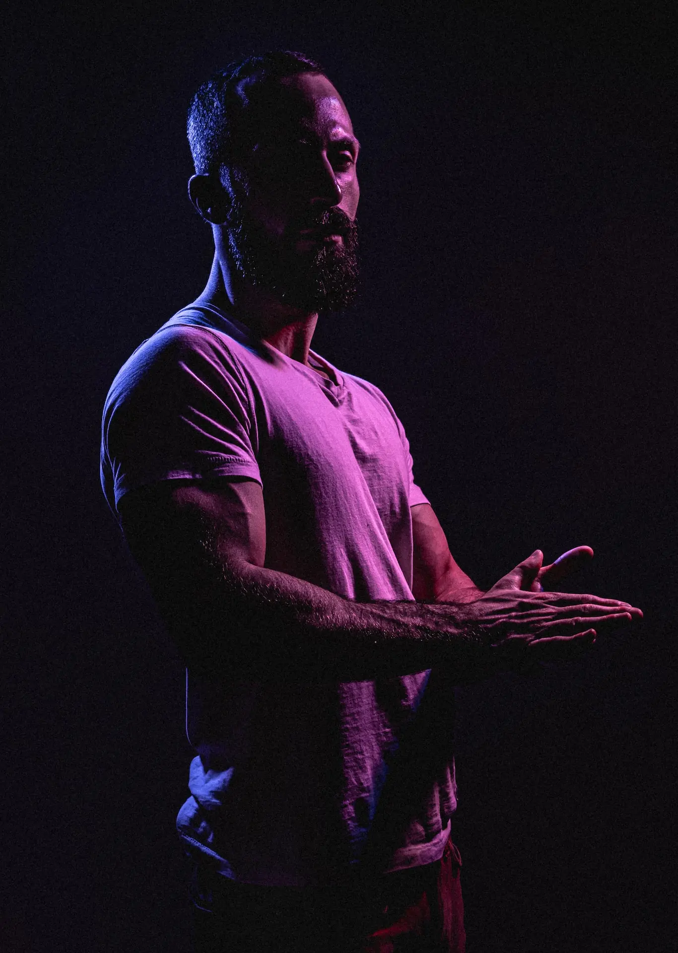 a man standing in the dark holding his hands open